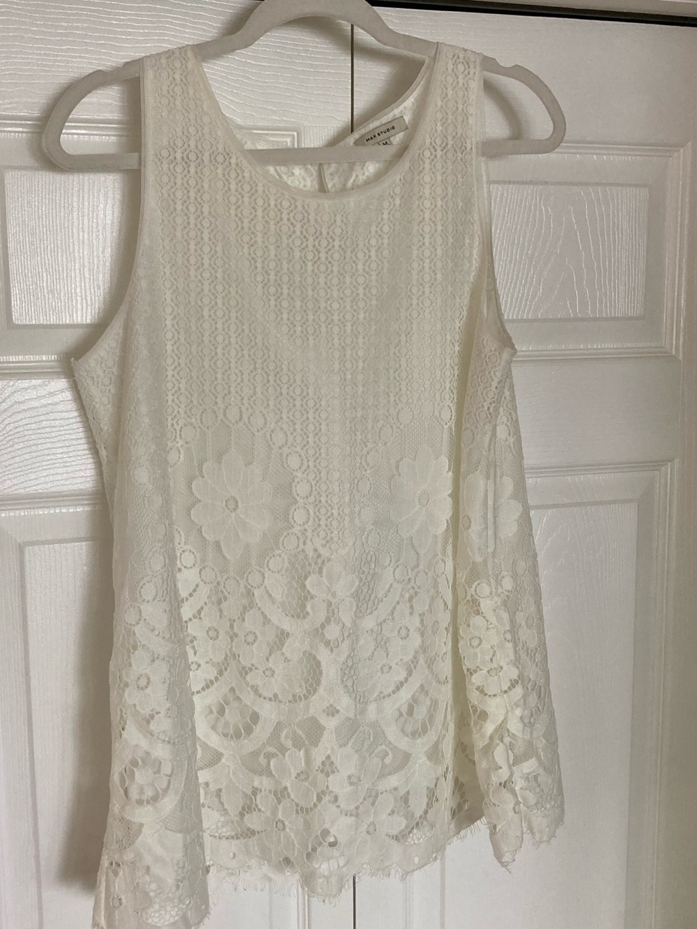 Sleeveless white blouse with floral lace overlay
